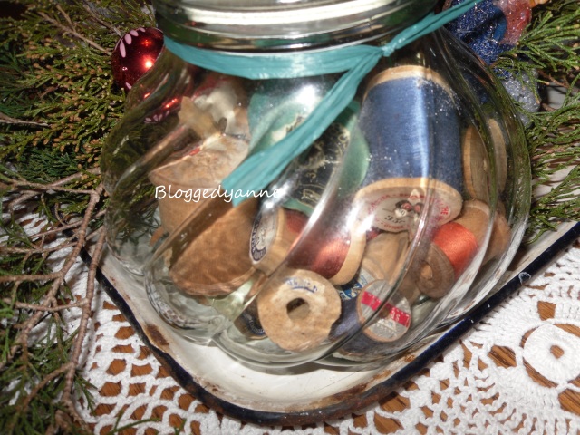 Old wooden thread spools in a jar